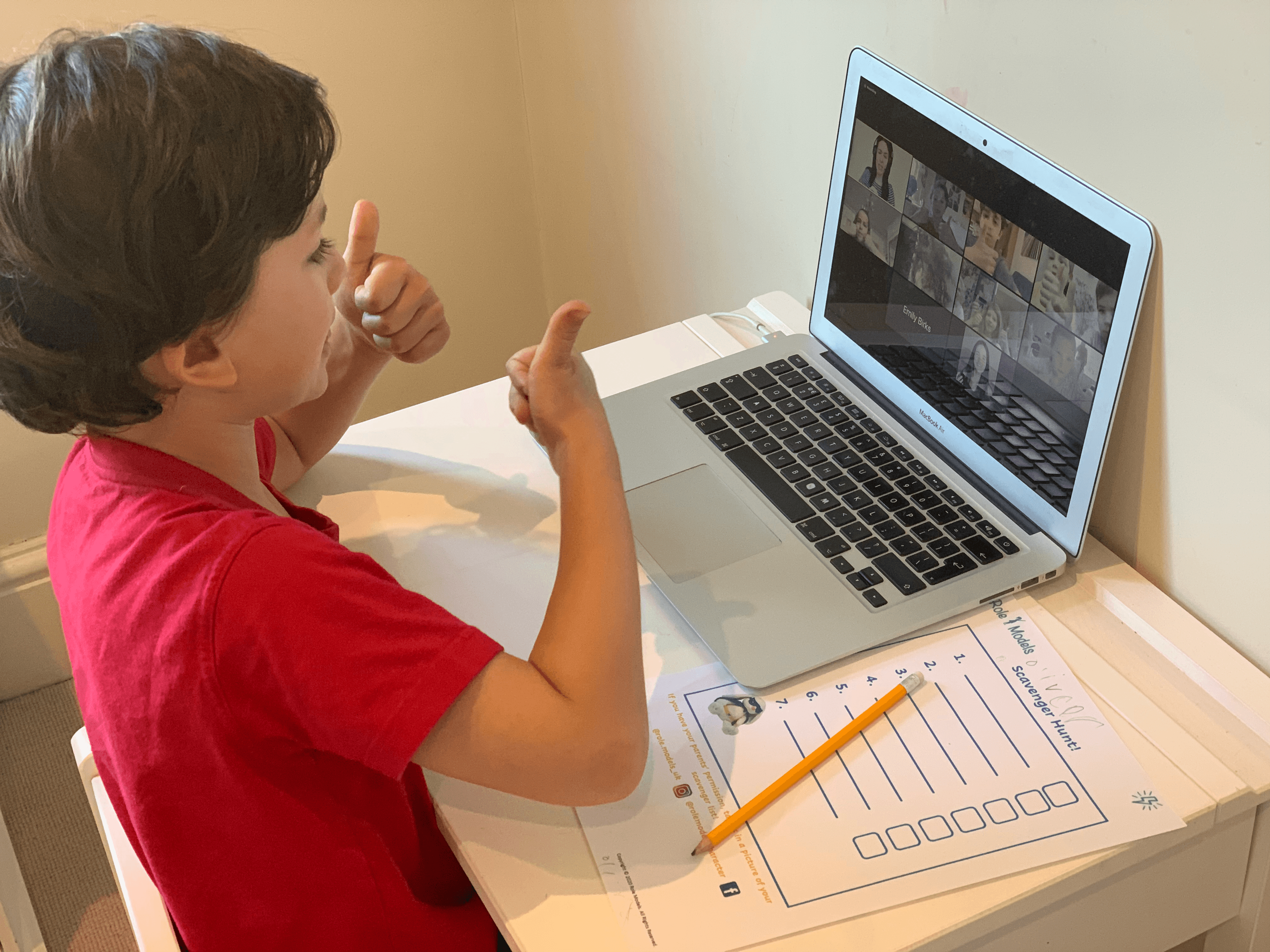Boy smiling while online with role models and class.
