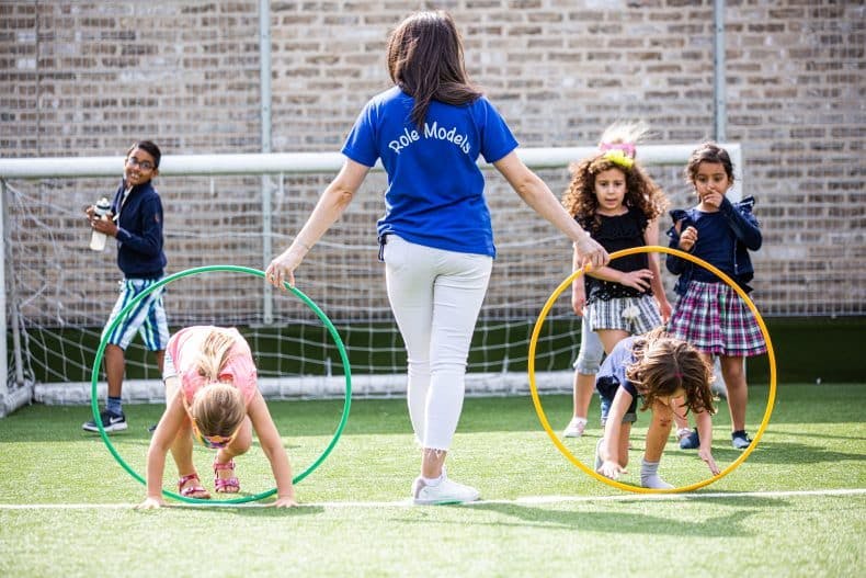 Role model running a game with hula-hoops.