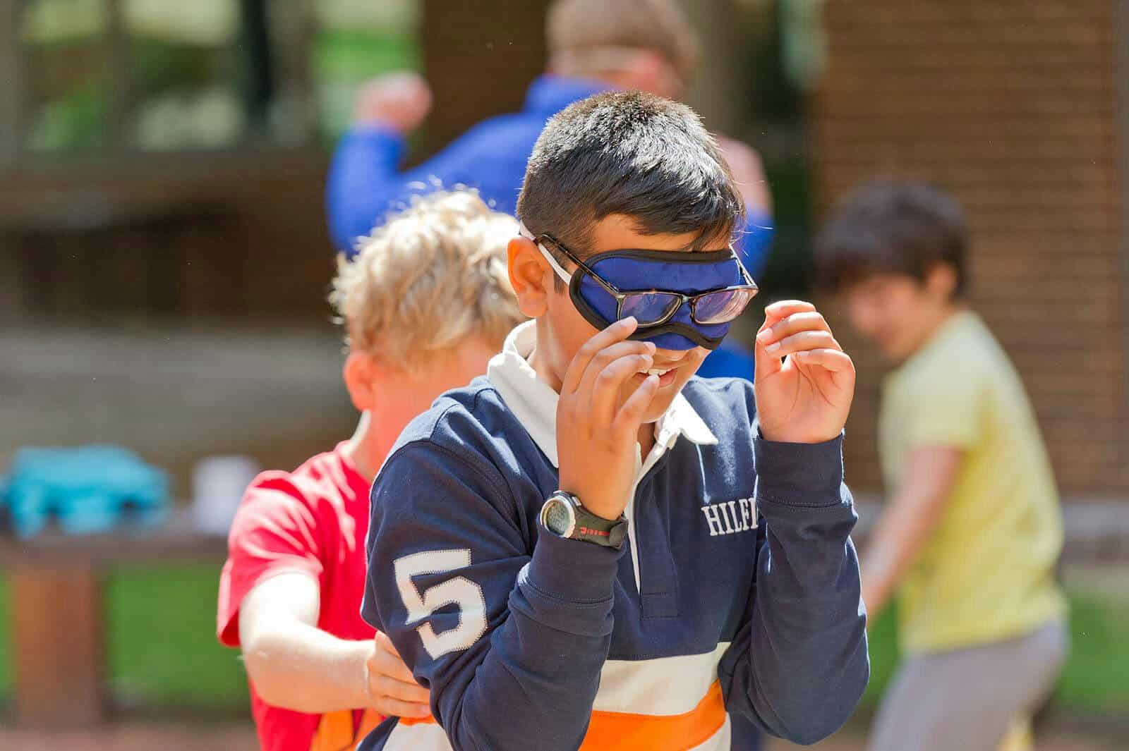 Child wearing mask playing trust game.