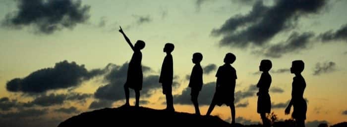 silhouette of kids pointing at the sky