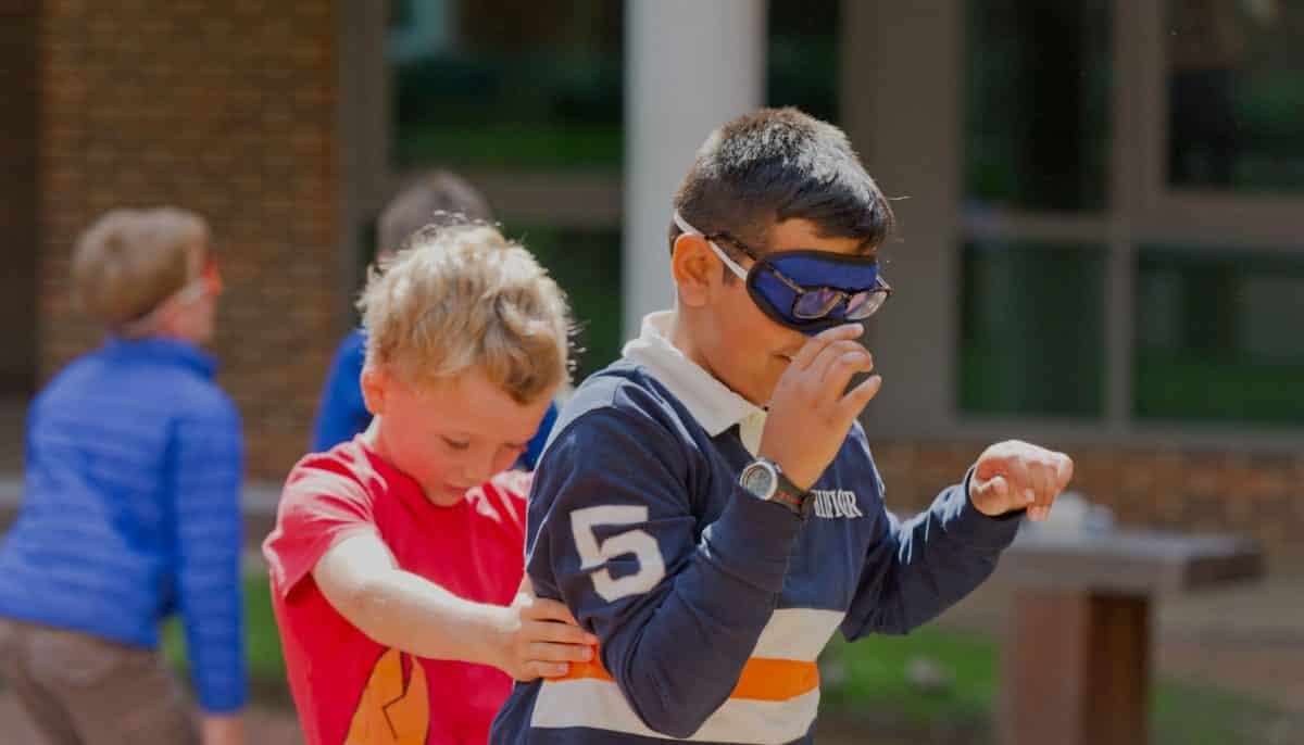 1 kid leading another - blindfold